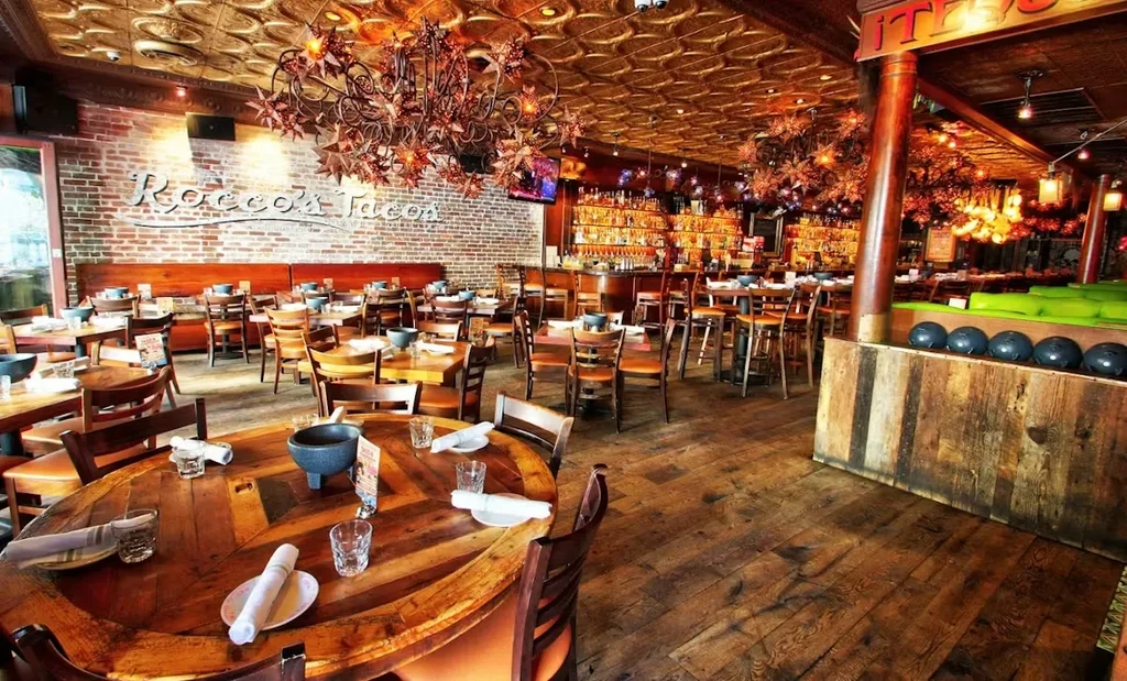 Rocco's Tacos restaurant interior with rustic decor, bar, and bowling section.