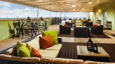 Spacious outdoor lounge and dining area overlooking a city.