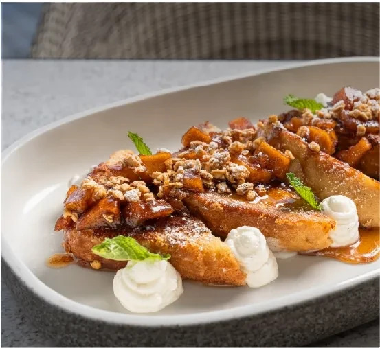 French toast, caramelized fruit, streusel, whipped cream, and mint leaves.