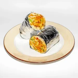 Two burrito halves, foil-wrapped on a plate, show chicken, rice, greens.