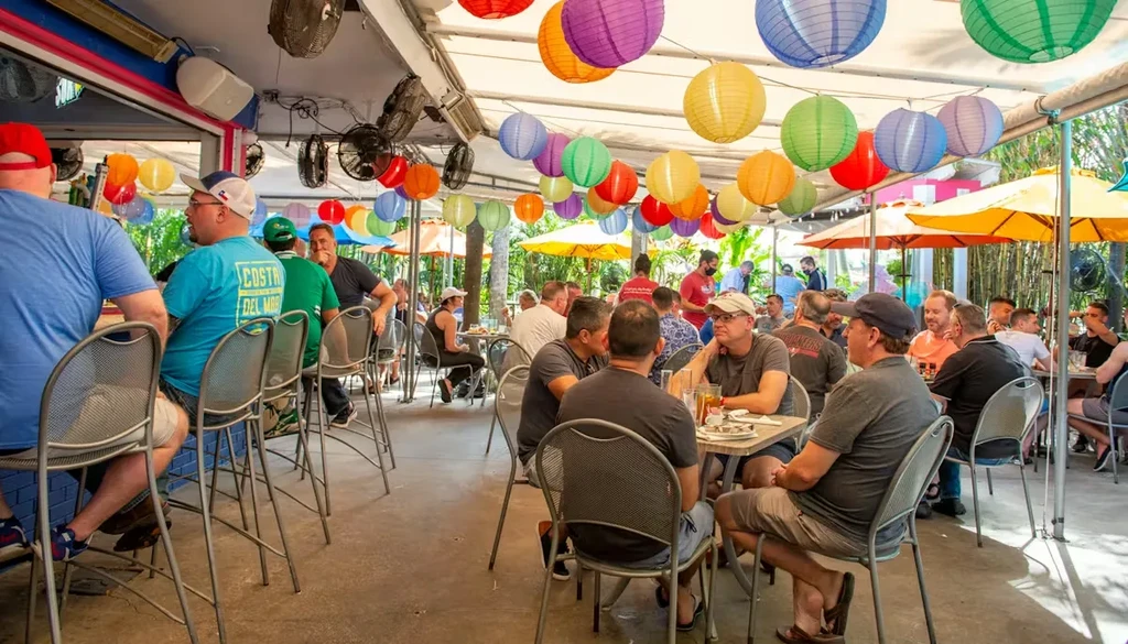 Bustling outdoor restaurant with colorful lanterns and patrons socializing.