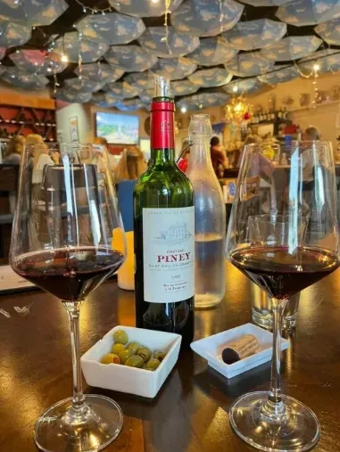 Chateau Piney wine, glasses, olives, with umbrella ceiling decoration.