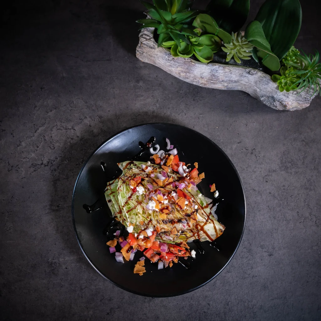 Grilled lettuce wedge with tomatoes, feta, onions, crispy bits, balsamic glaze.