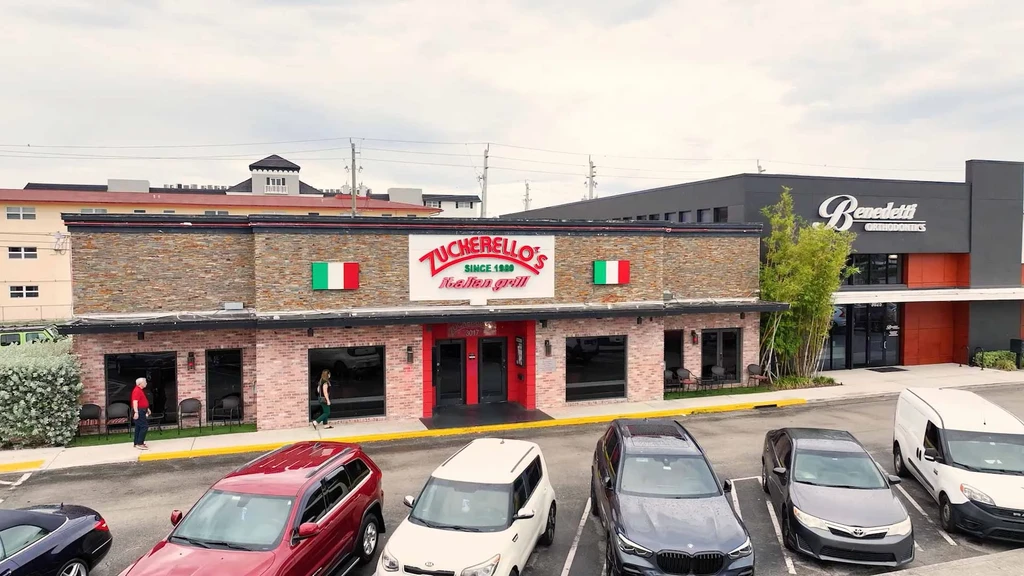 Elevated view: Zucherello's Italian Grill, a brick building with a full parking lot.