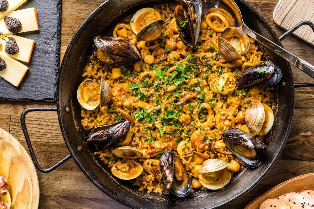 Overhead view of seafood paella with mussels, clams, squid, and shrimp.