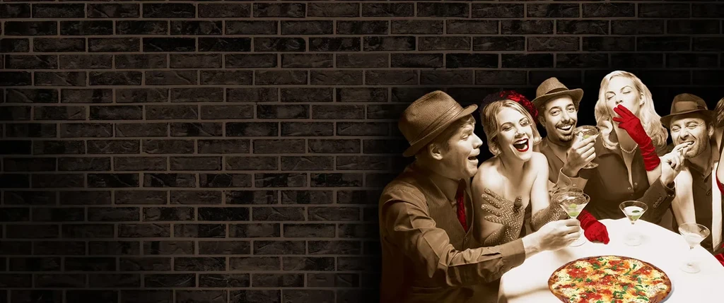 Vintage-dressed group laughs over pizza and martinis, sepia with red accents.