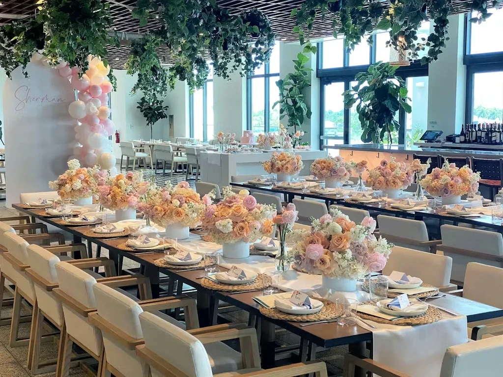 Elegant event venue with set tables, flowers, and 'Sherman' arch.
