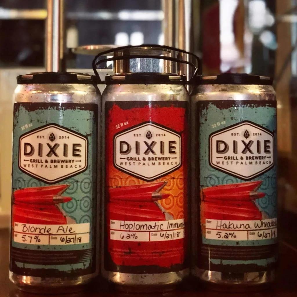 Three distressed cans of Dixie Grill & Brewery craft beer.