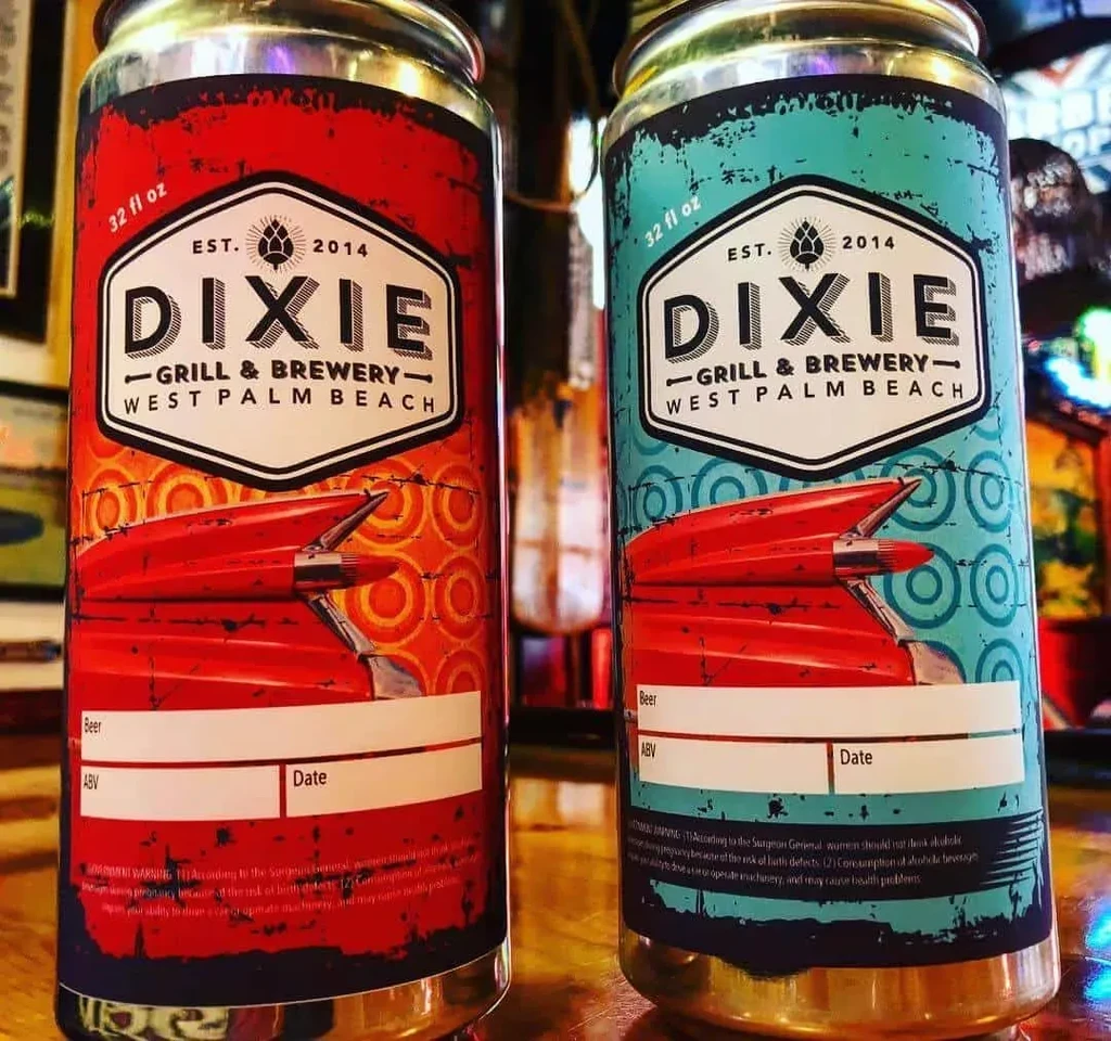Red and blue Dixie Grill & Brewery 32oz beer cans with car fin graphic.
