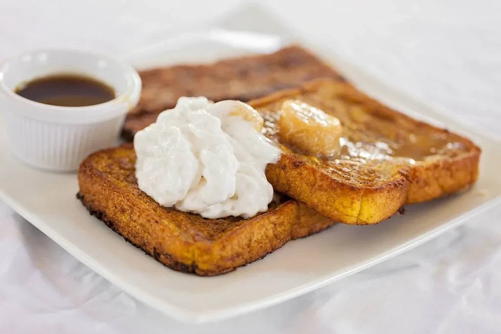 Golden French toast, whipped cream, caramelized bananas, amber syrup.