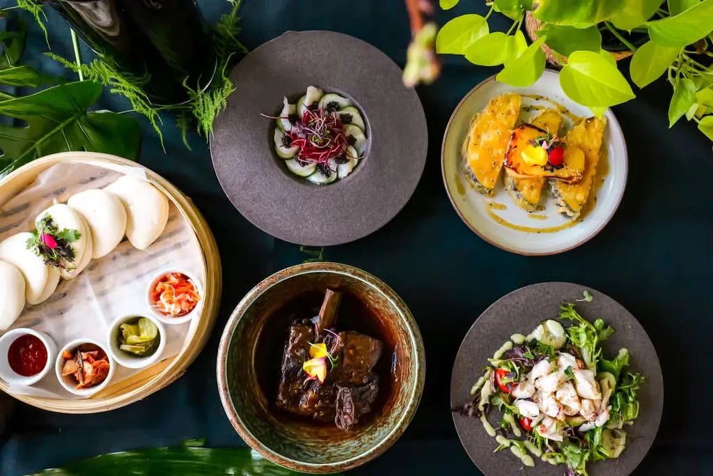 Top-down view of meticulously plated gourmet dishes with foliage.