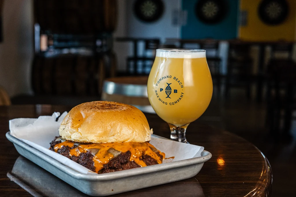 Double cheeseburger and Pompano Beach Brewing Company beer at a brewery.