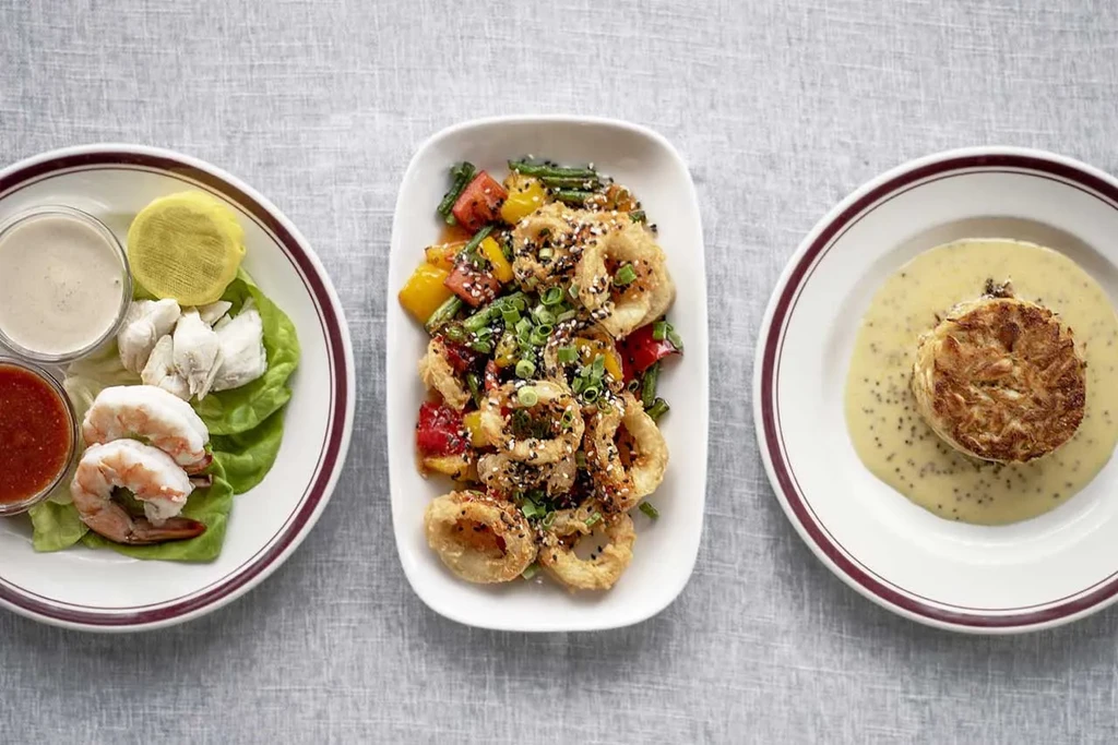 Three seafood dishes: shrimp, calamari, and crab cake.