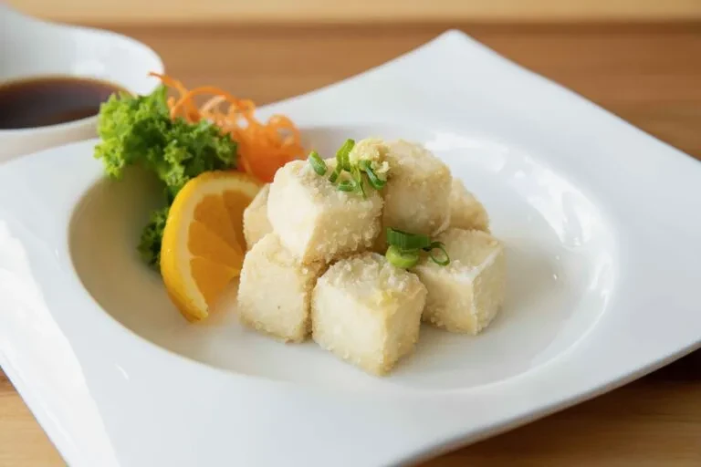 Golden-brown tofu cubes with green onions, ginger, lemon, and dipping sauce.