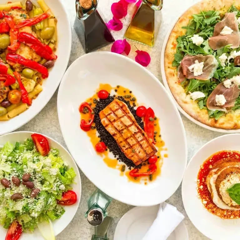 Overhead view of a restaurant table with various colorful, appealing dishes.
