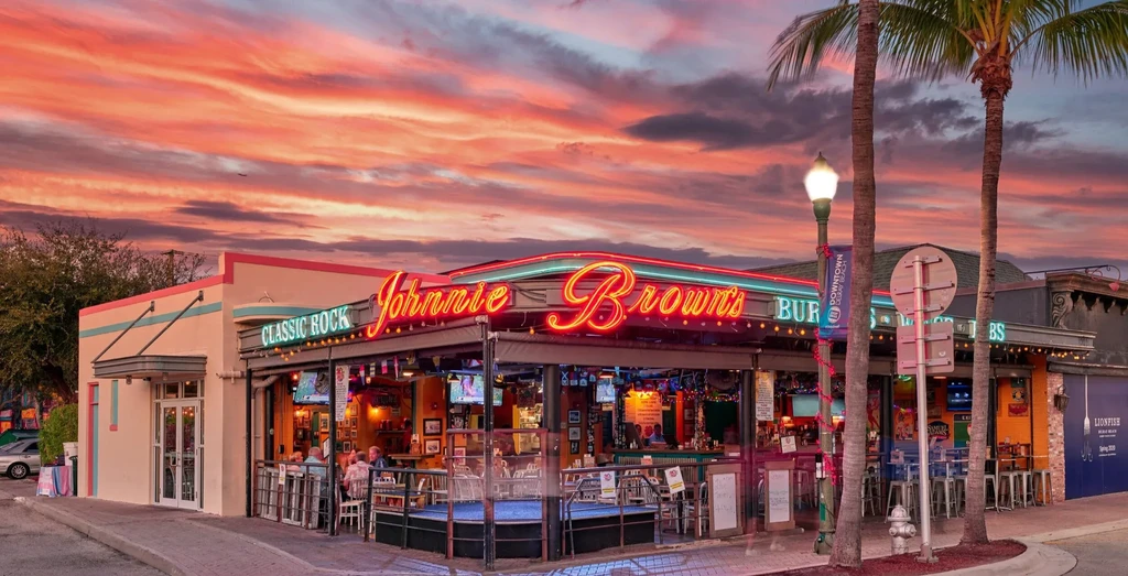 Johnnie Brown's restaurant exterior at dusk with glowing neon and sunset.