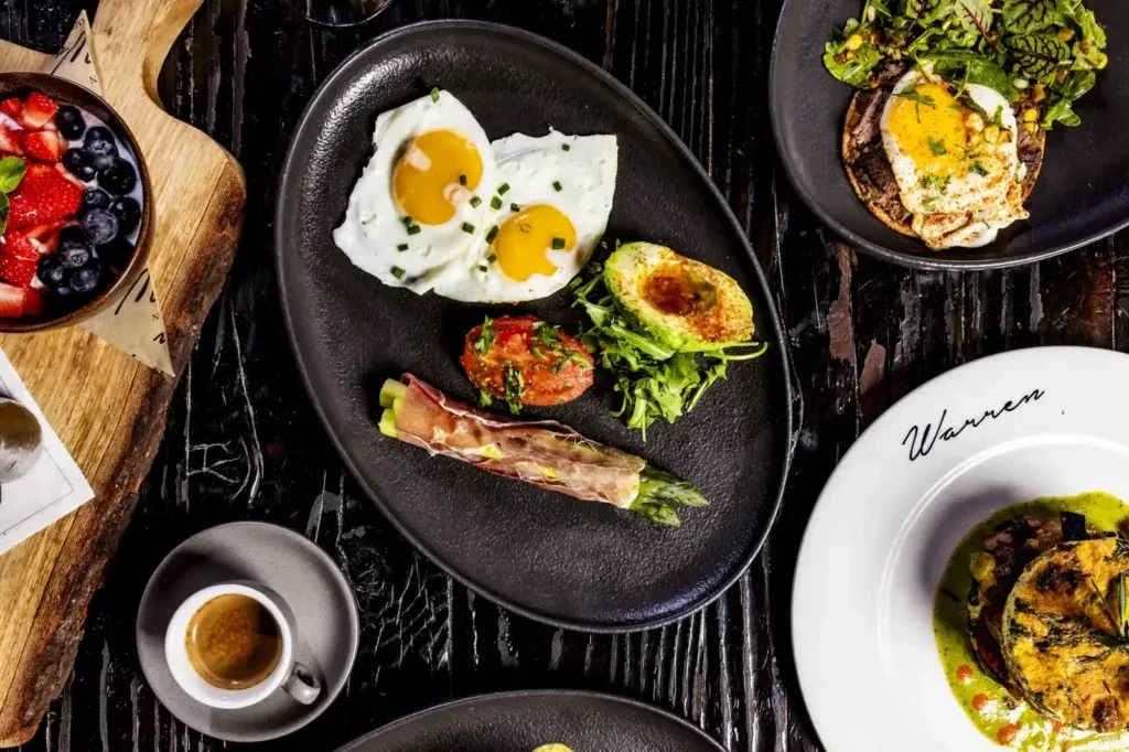 Gourmet breakfast and brunch spread on a dark rustic wooden table.