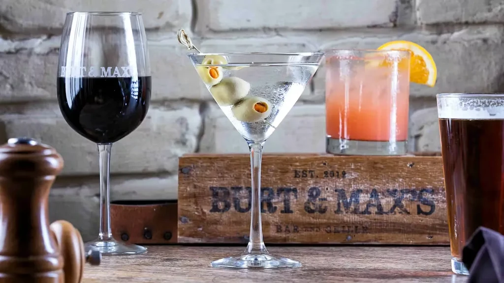 Burt & Max's branded wine, martini, cocktail, and beer on wood.