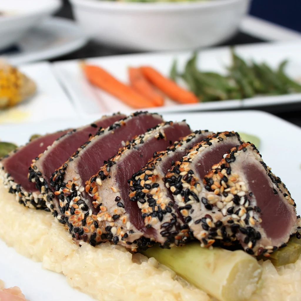 Seared sesame-crusted tuna slices on risotto with asparagus.