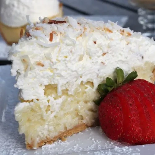 Dessert slice with whipped cream, shredded coconut, and a strawberry.