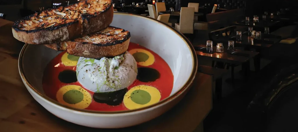 Creamy burrata with red sauce, herbs, and toasted almond bread.