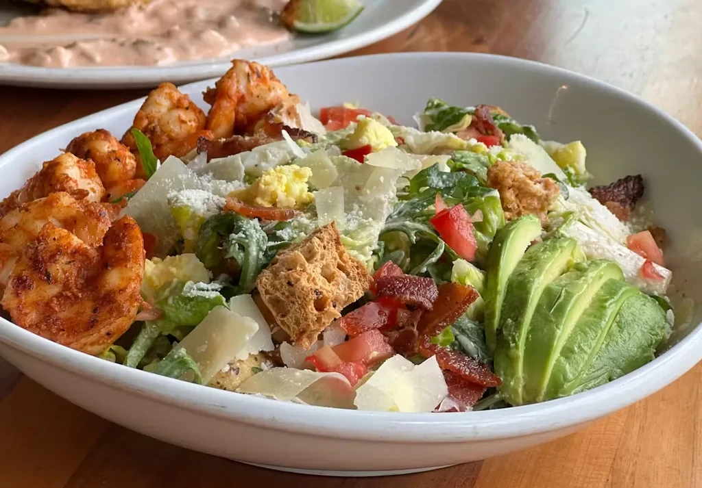 Grilled shrimp salad with avocado, bacon, eggs, and creamy dressing.