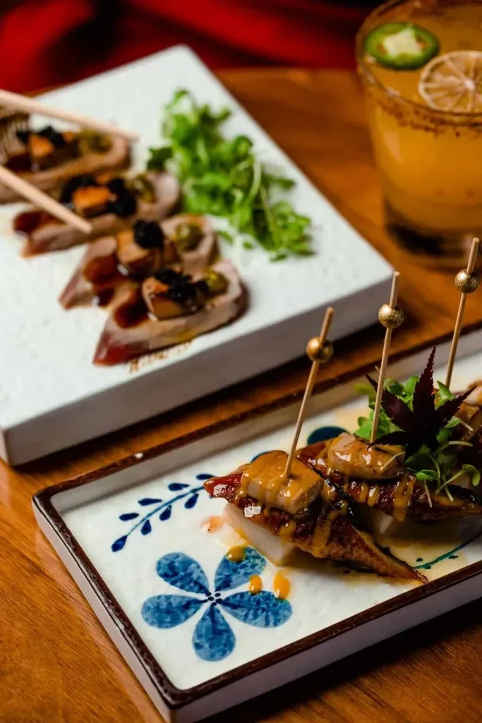 Eel, seared tuna, and a spicy cocktail on a wooden table.