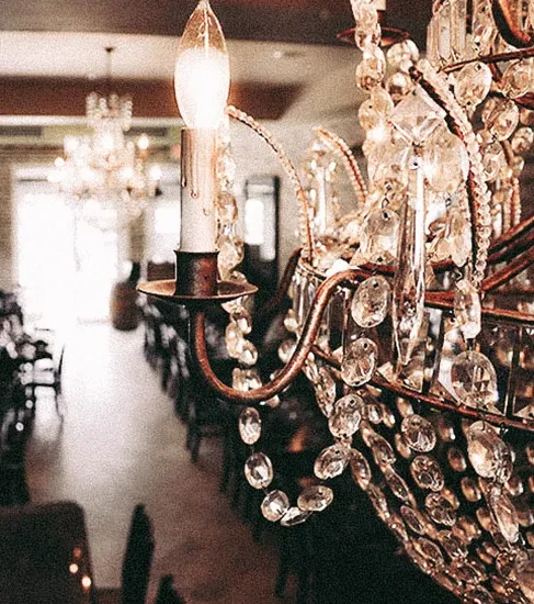 Close-up of a sparkling crystal chandelier in a warm, elegant dining room.