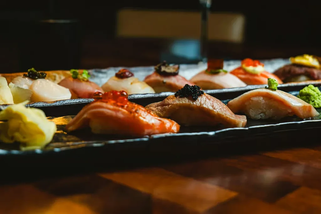 Elegantly arranged colorful nigiri sushi platter with ginger and wasabi.