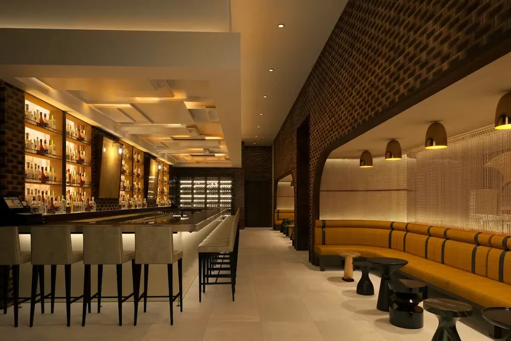 Modern bar interior with illuminated liquor shelves and curved yellow seating.