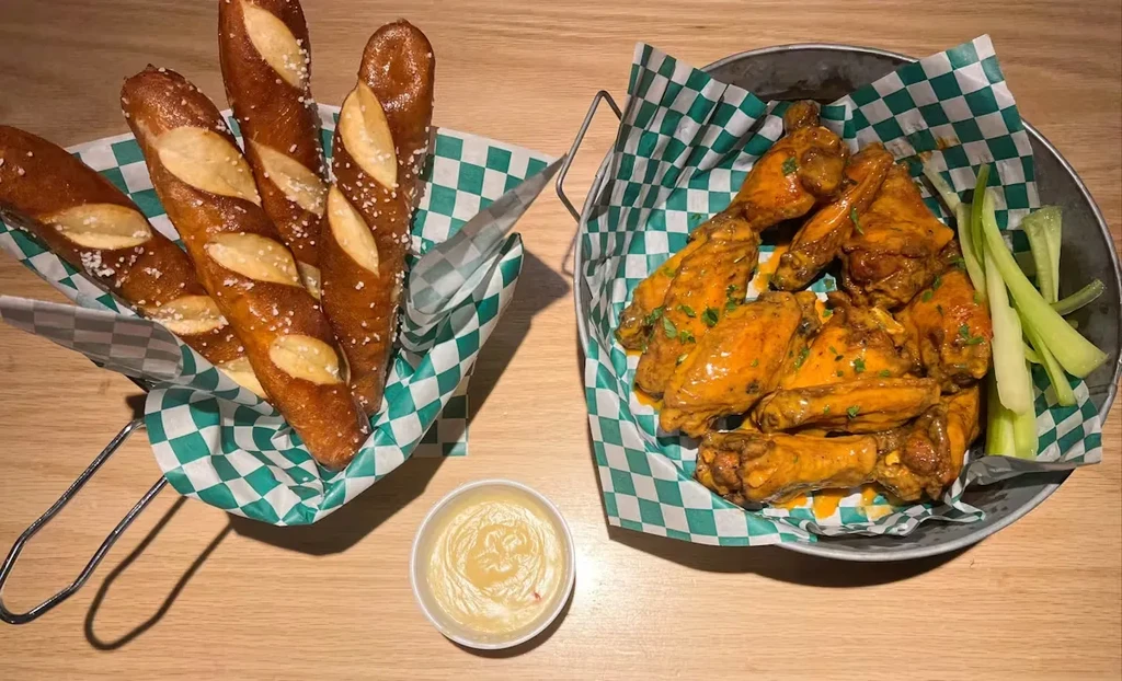 Golden pretzel sticks and sauced chicken wings with celery and dip.