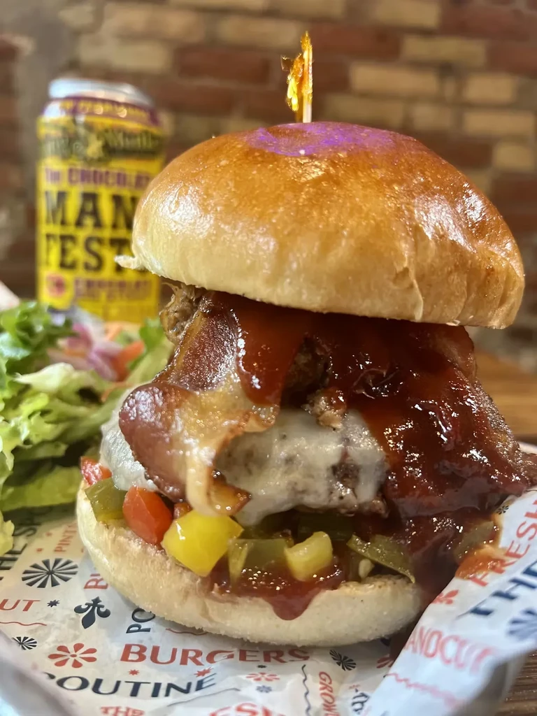 Gourmet brioche burger with melted cheese, bacon, BBQ sauce, relish.