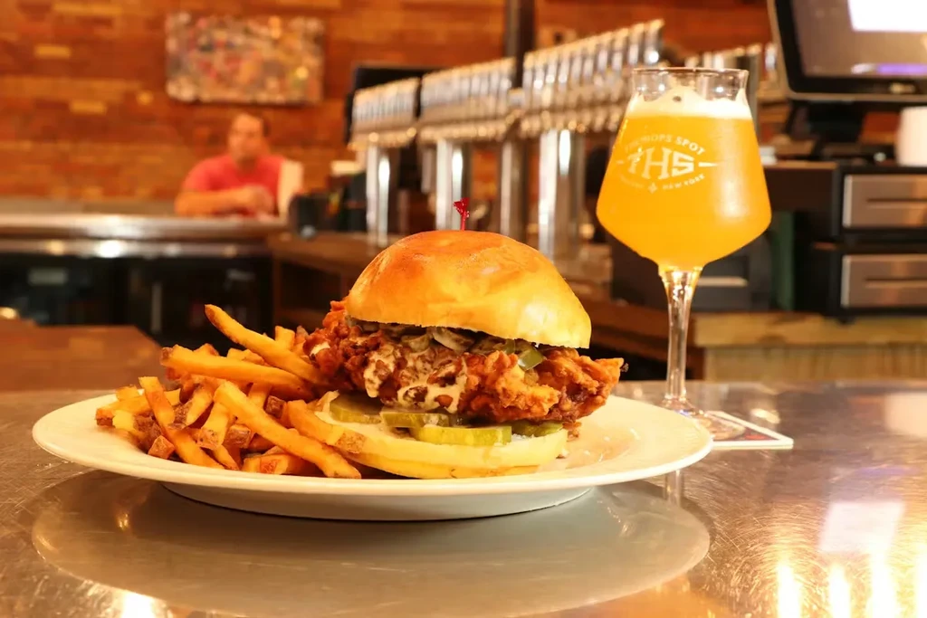 Fried chicken sandwich, golden fries, and The Hops Spot craft beer.