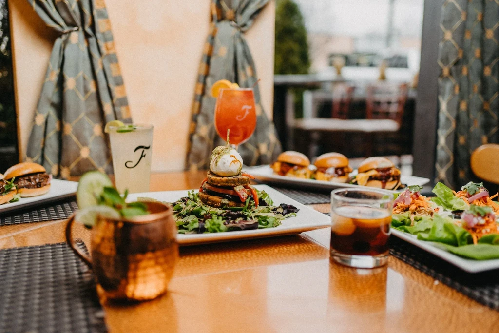 Appetizers and drinks are on a table in a restaurant.