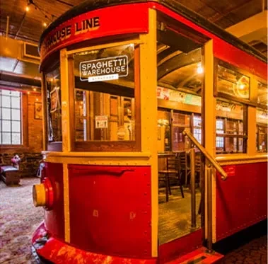 Red vintage trolley car inside a Spaghetti Warehouse restaurant.