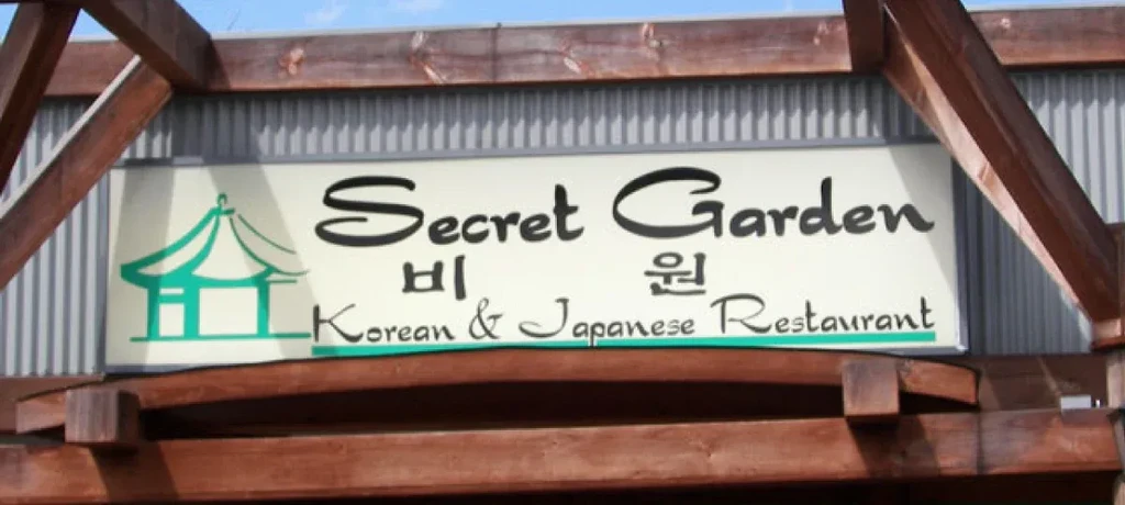 Restaurant sign: Secret Garden Korean & Japanese, framed by wooden beams.