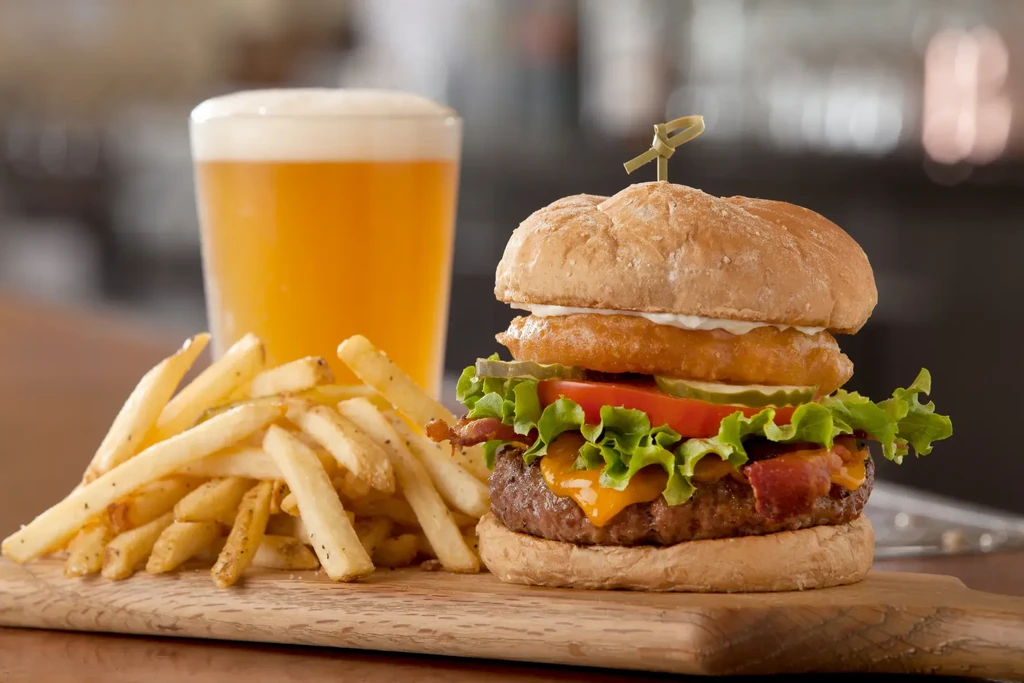 Gourmet burger, golden French fries, and amber beer.