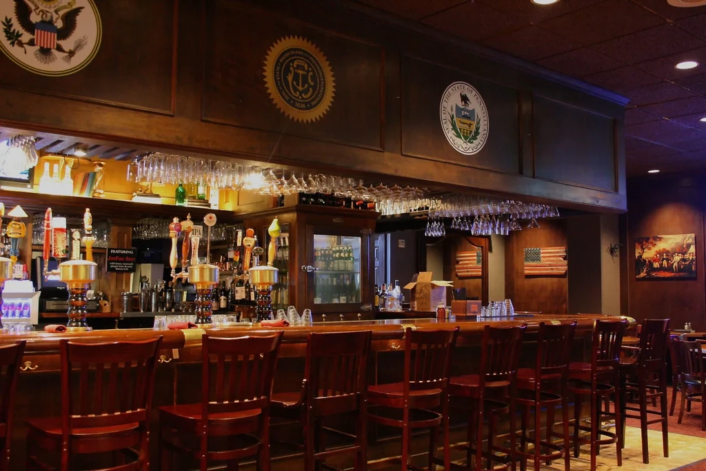 A dimly lit bar with many empty stools and three seals.