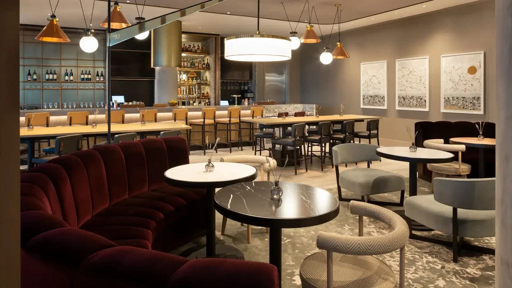 A modern bar and lounge with varied seating and ambient lighting.