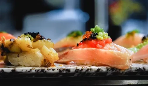 Close-up of nigiri sushi on a counter, with toppings like roe.