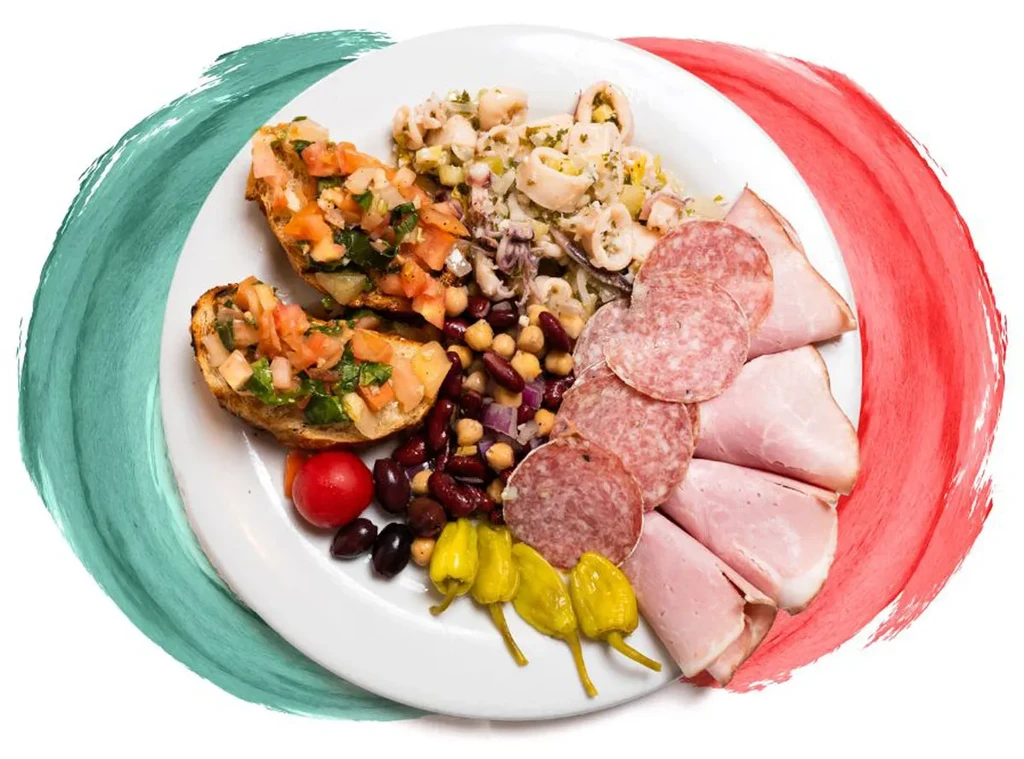 Italian flag-themed plate of bruschetta, calamari salad, charcuterie, and beans.