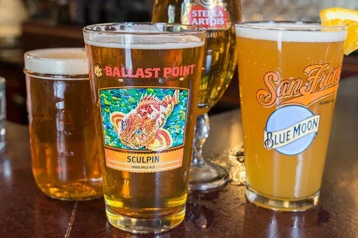 Three glasses of beer on a wooden table.