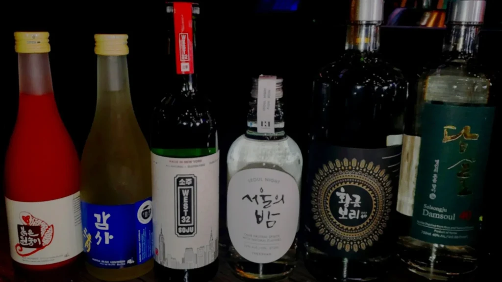 Six bottles of Korean soju and rice wine against a dark background.