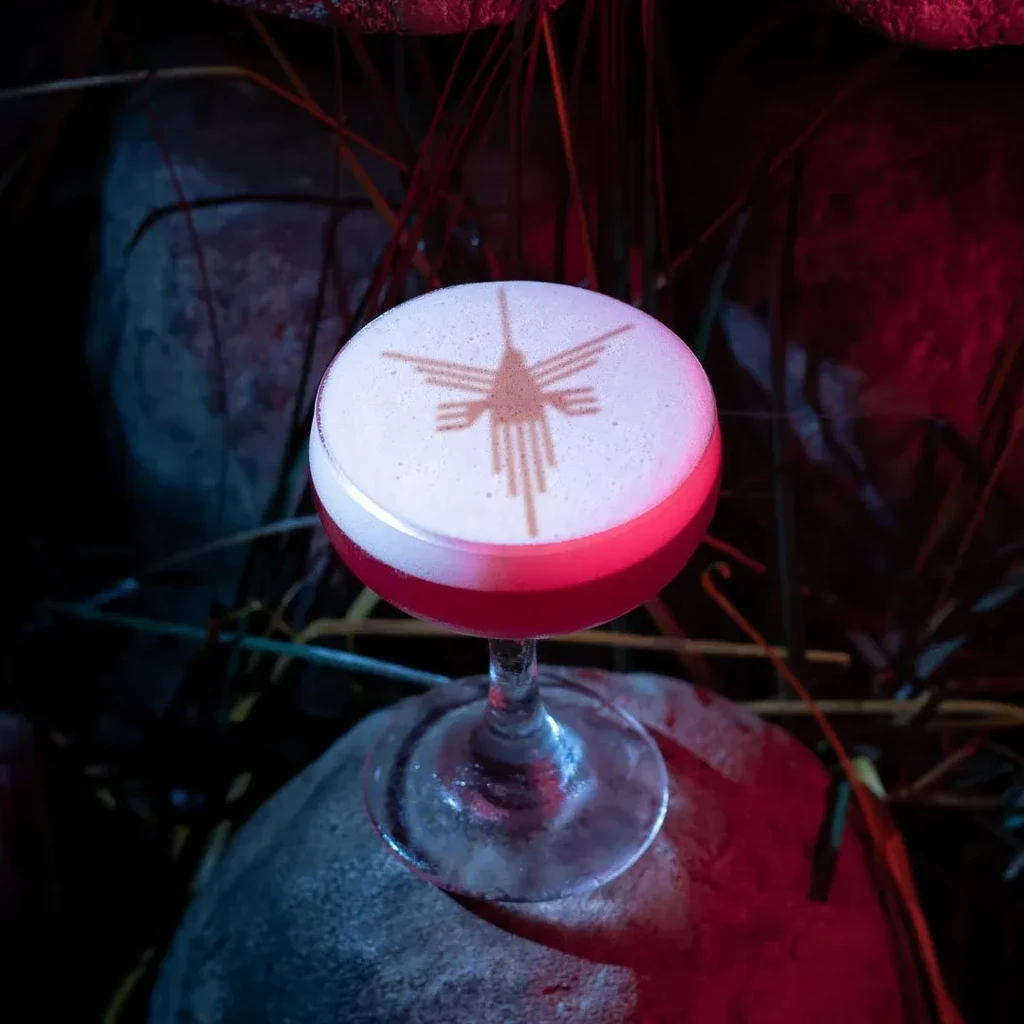 A cocktail with foamy top, an abstract pattern, on a rock.