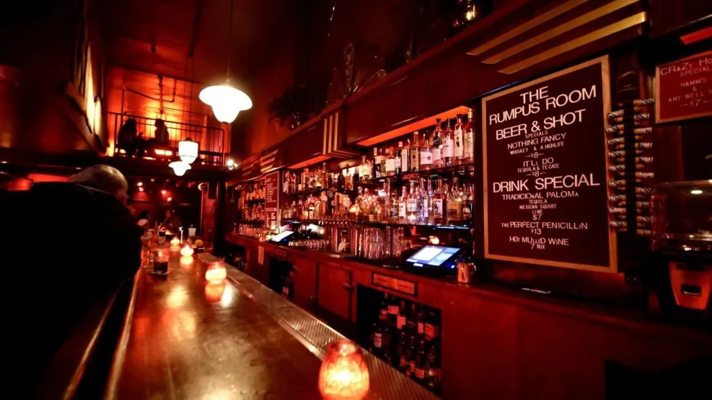 A bar bathed in red light, with a menu board.