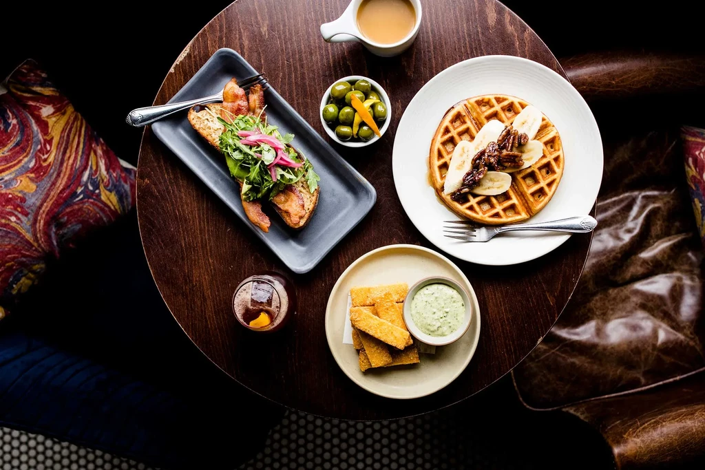 Overhead view of a wooden table with various dishes and drinks.