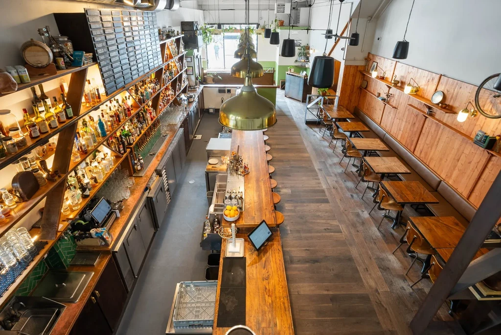 Overhead shot of a rustic bar with a long counter and many bottles.