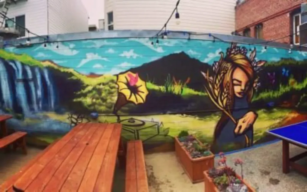 Patio with mural of nature, gramophone, and a woman.
