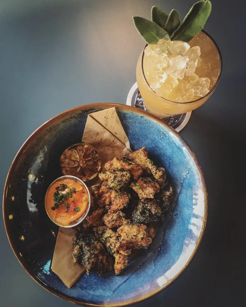 Fried chicken, dipping sauce, and an iced drink with sage garnish.
