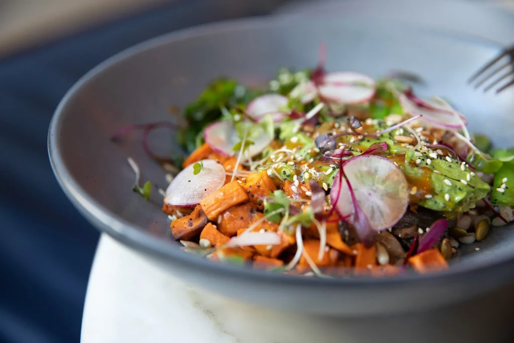A close-up of a colorful salad in a gray bowl.